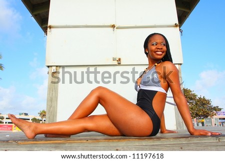 Woman sitting on a lifeguard stand and smiling