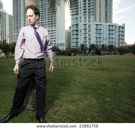Businessman standing in a green field at the park