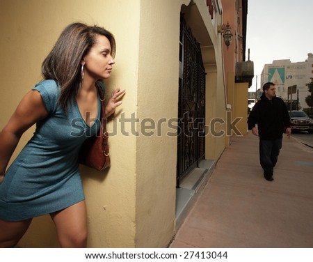 Woman hiding from a thug in the city