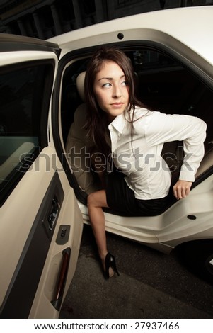 Beautiful young woman exiting her car