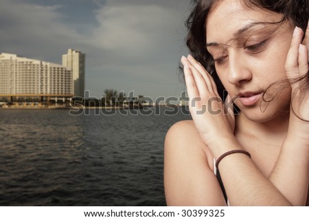 Young woman looking down with hands on her face