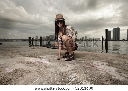 Beautiful woman squatting with a cityscape in the background