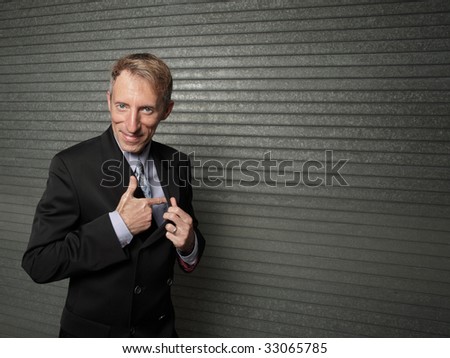 Businessman pretending to pull out a gun from his jacket