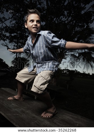 Young boy pretending to surf on a table