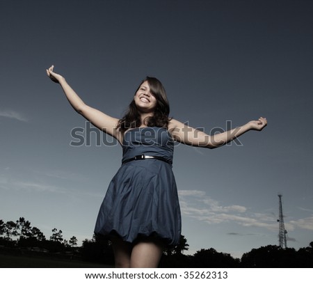 Young woman outside with her arms extended outward