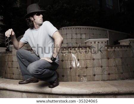 Cool guy squatting by a building