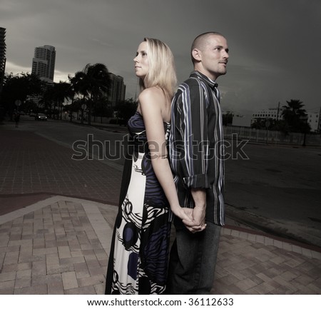 Couple holding hands and facing away from each other