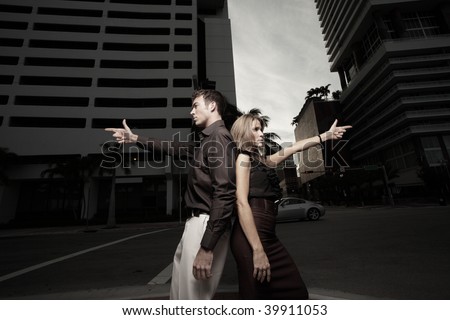 Couple pointing finger guns in the city