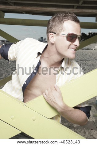 Man posing by a lifeguard tower