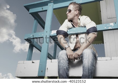 Man sitting on a wooden lifeguard tower