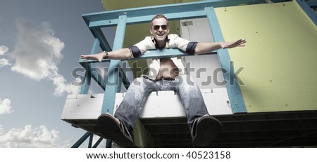 Man hanging from a lifeguard tower