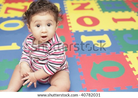 Adorable baby on a alphabet play mat
