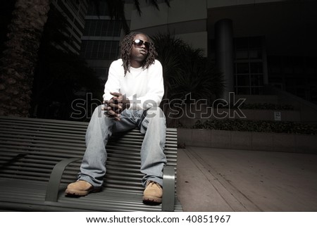 Young urban male sitting on a bus bench