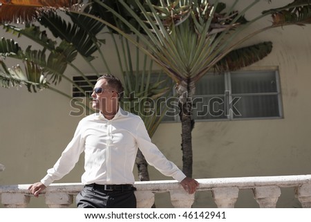 Man posing by a building ledge