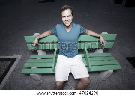 Unusual angle of a man sitting on a bus bench