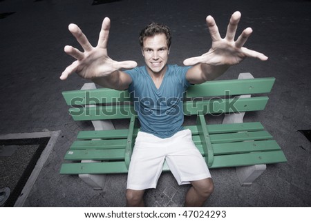 Man sitting on a bench and reaching towards the camera