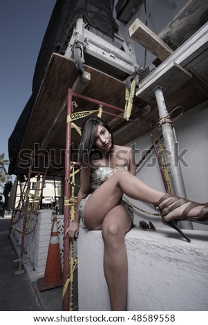 Woman sitting on a ledge with her legs crossed