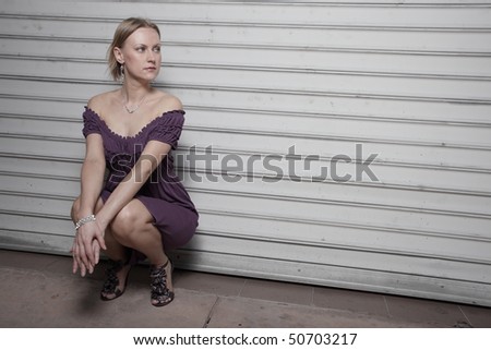 Young woman squatting and glancing over her shoulder