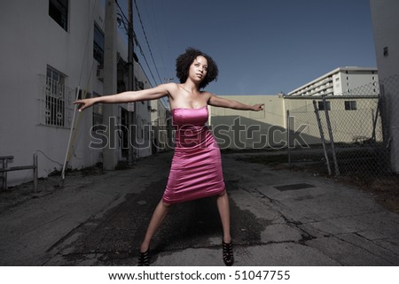 Woman posing in the alley with her arms extended