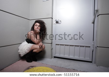 Woman squatting in the corner