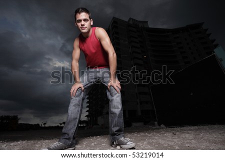 Image of a man posing with his hands on his knees