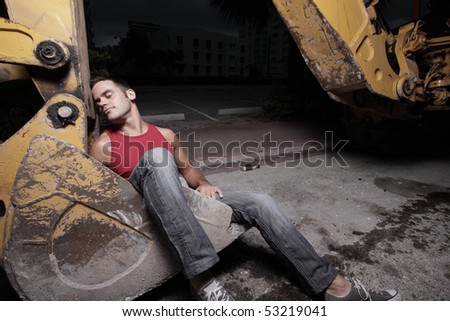 Man in the shovel of a backhoe loader