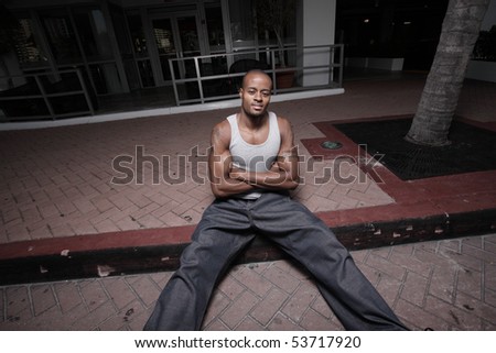 Unusual angle of a man sitting on the curb with arms crossed