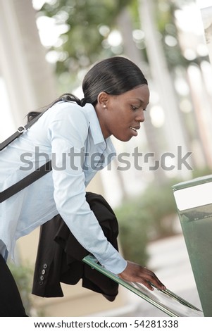 Attractive woman grabbing a newspaper from the stand