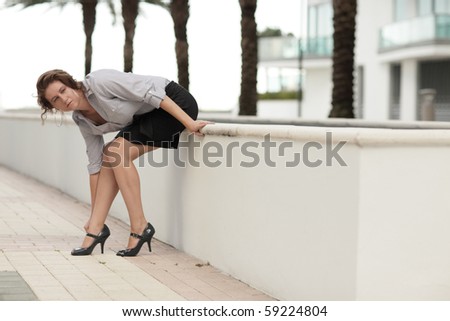 Woman sitting and adjusting her shoe