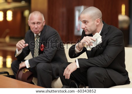 Businessman crying over the other businessman's money