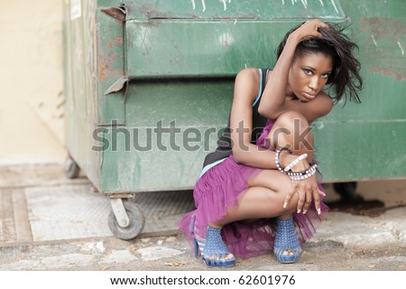 Young model posing by a dumpster