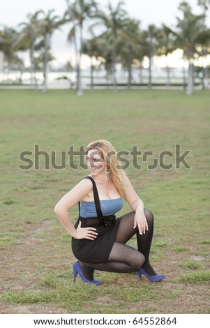 Woman squatting in a field in the park