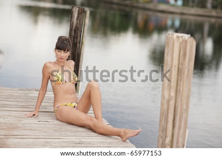Woman in a bikini sitting on the boating deck