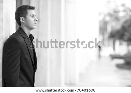 Profile image of a businessman leaning on the wall