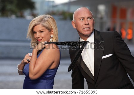 Woman pulling the man by his tie