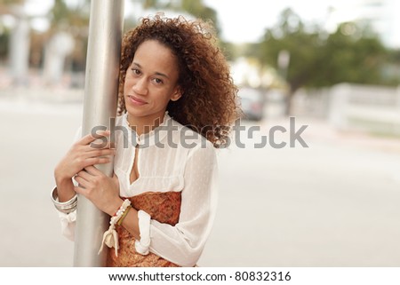 Woman with arms around a pole