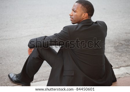Unemployed businessman sitting on the curb