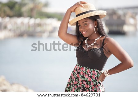 Beautiful black woman tipping her hat and smiling
