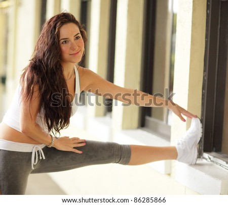 Image of a young woman stretching her legs