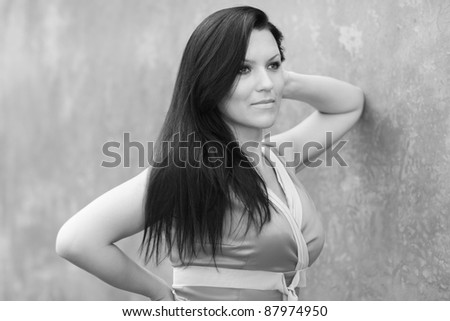 Black and white image of a woman leaning on the wall