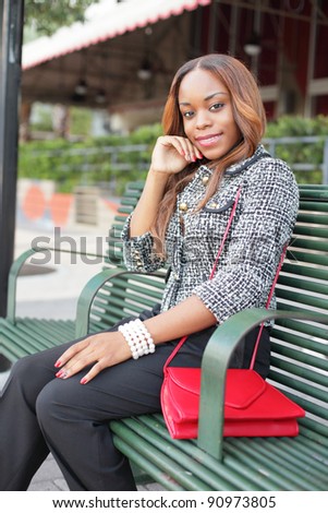 Beautiful young woman sitting on a bus bench