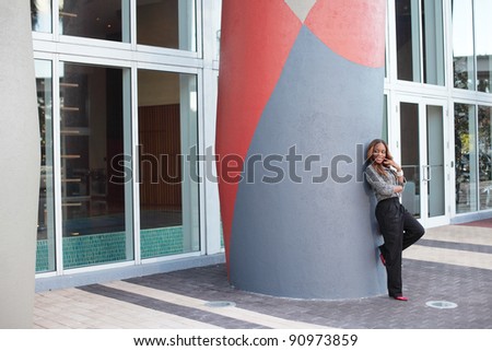Woman leaning on a building column