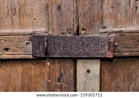 Old rusty door hinge on wooden door