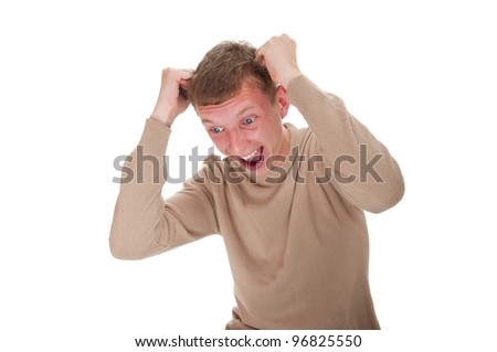 Studio portrait of angry young man tearing his hair. He is expressive and isolated on a white background
