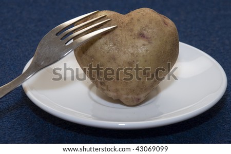 Root of potato in the form of heart rests on a plate