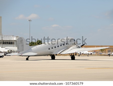 retro propeller airplane in metallic color parked on tarmac