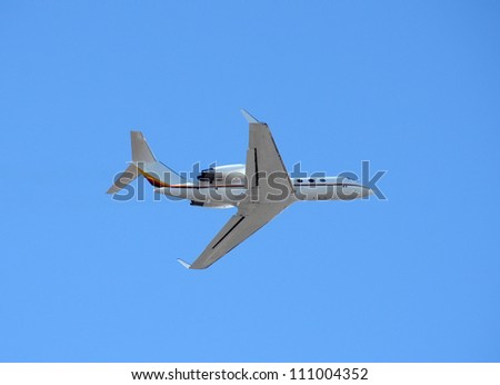 Luxury private jet departing in blue sky