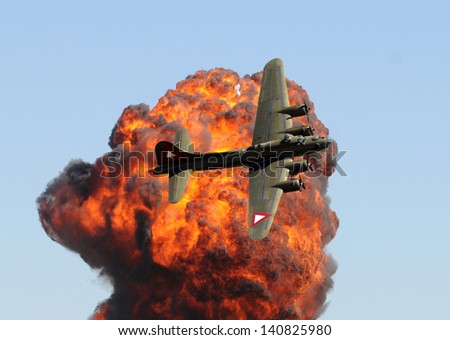 World War II era bomber in front of giant explosion