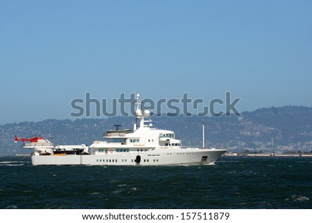 Luxury yacht with helicopter on the back side view