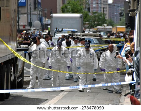NEW YORK - MAY 13: Crime scene investigator scour the scene of a street shooting in New York City on May 13, 2015. The fatal shooting involved police and an armed man